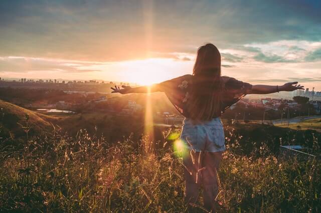 Happy woman watching sunrise