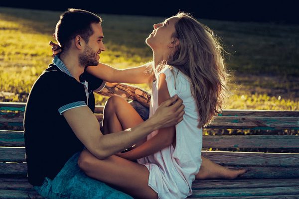 Man and woman cuddling on a bench